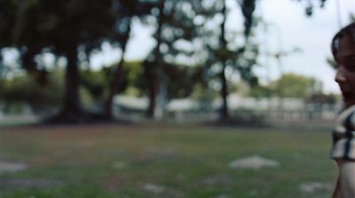 a woman standing in a park with a frisbee in her hand