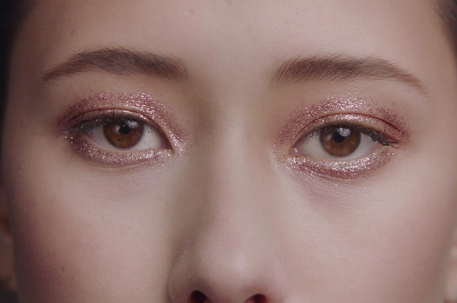 a close up of a woman's face with glitter on her eyes