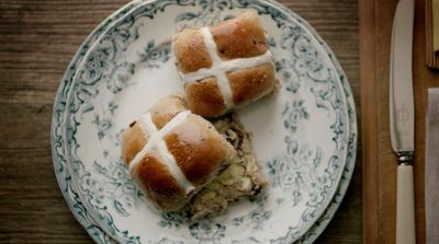 a white plate topped with two hot cross buns