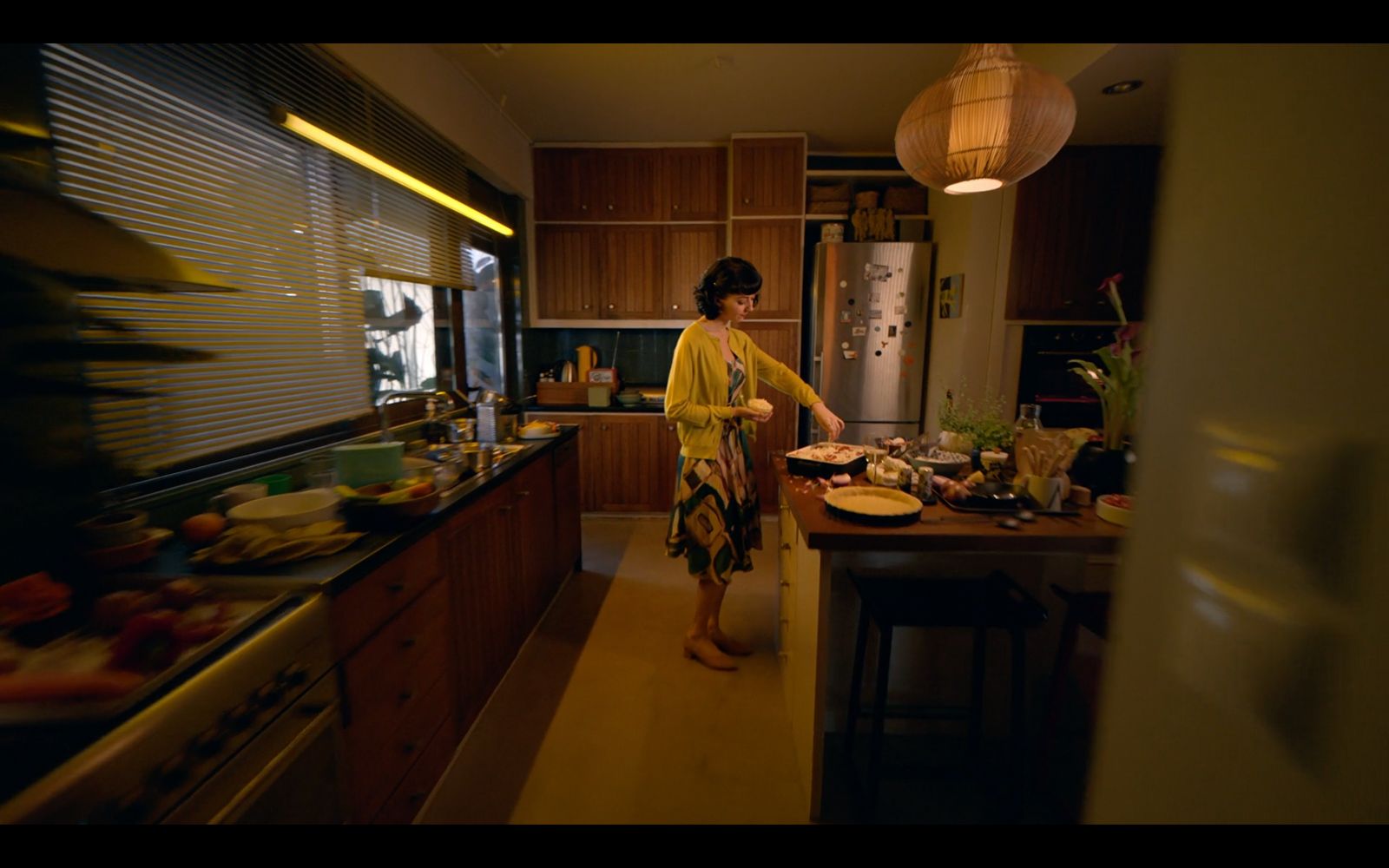 a woman standing in a kitchen preparing food