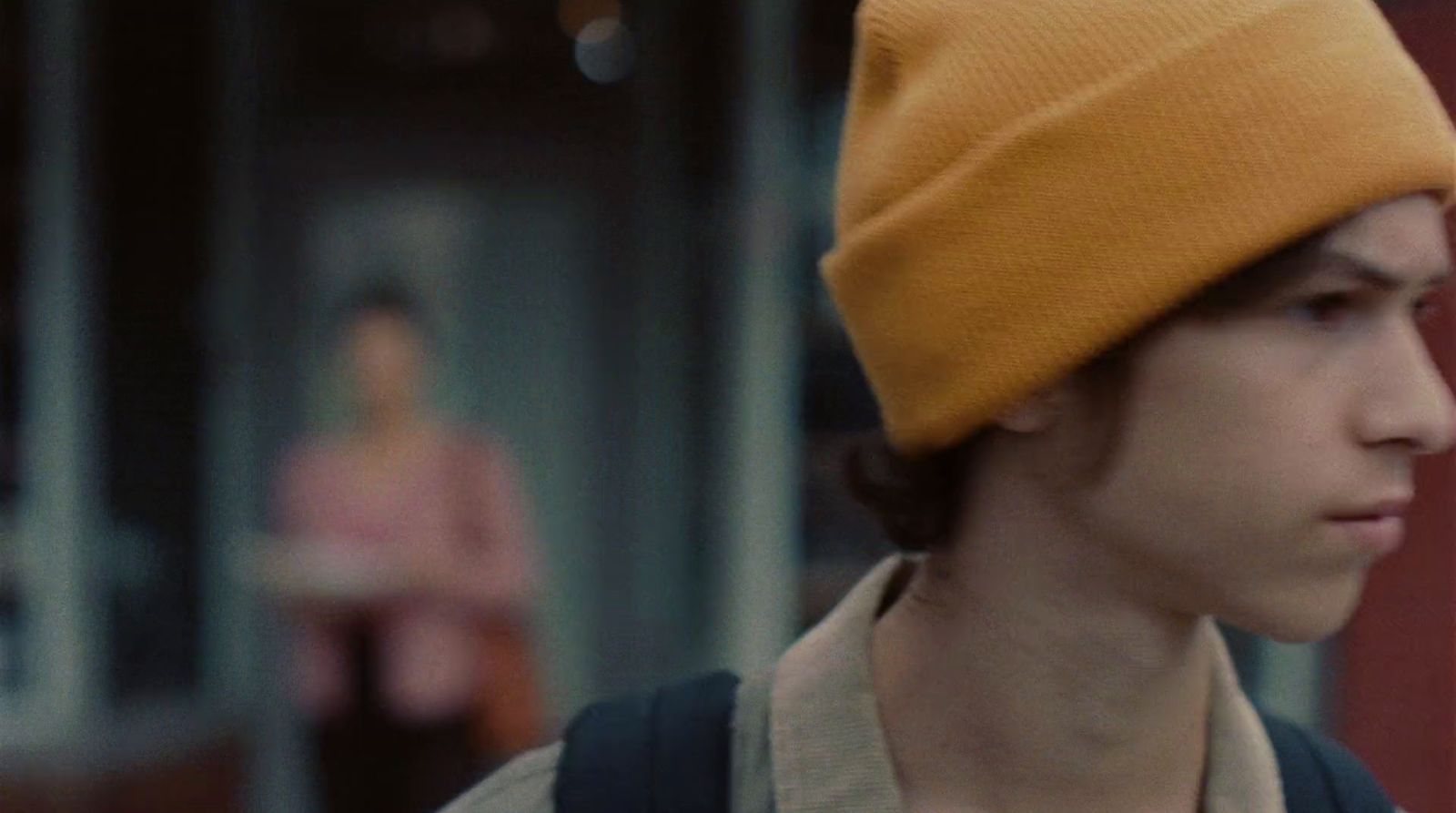a young man wearing a yellow hat and backpack