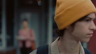 a young man wearing a yellow hat and backpack