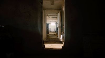 a dark hallway with a light coming through the door