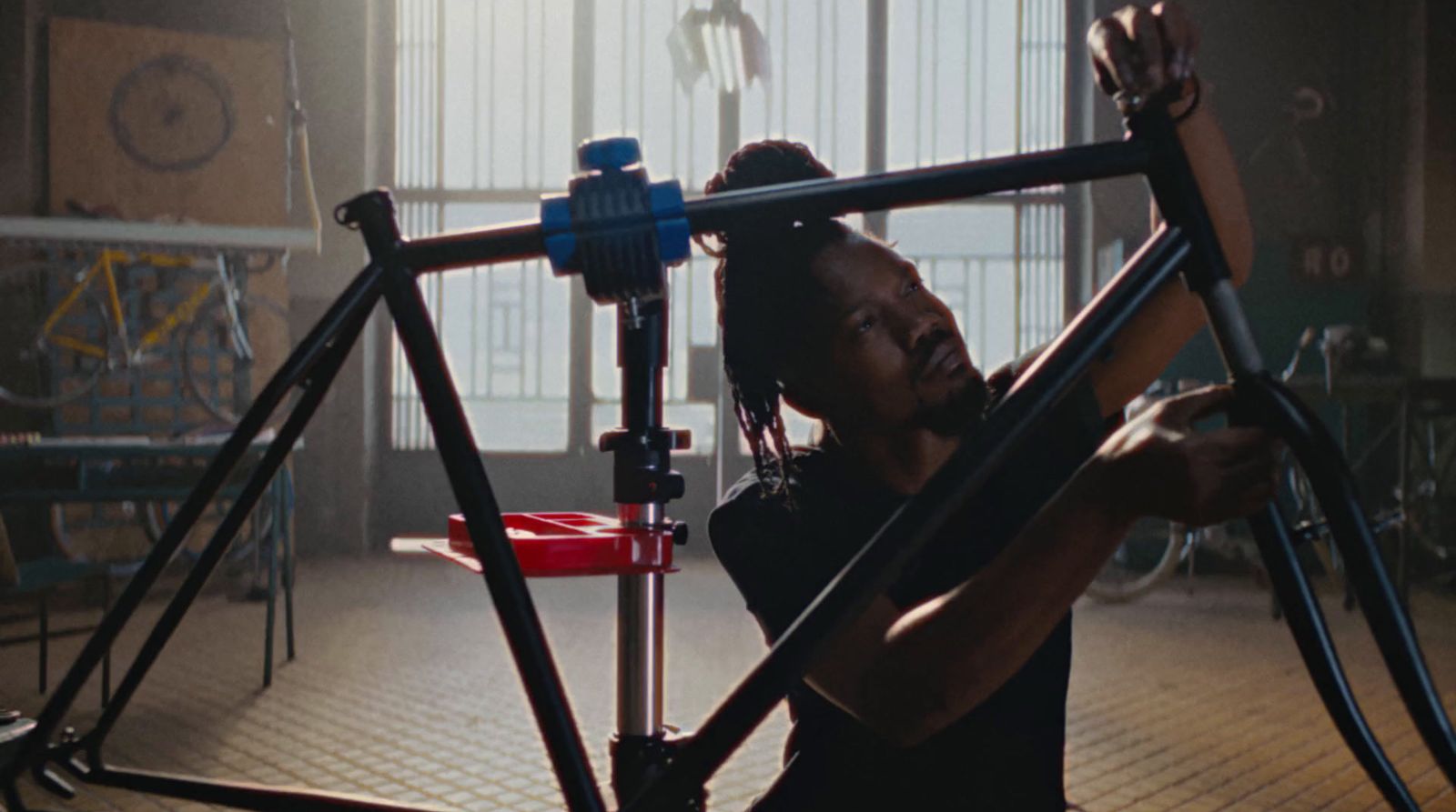 a man working on a bicycle in a garage