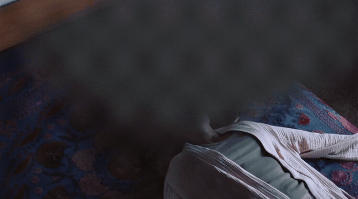 a person laying on a bed with their feet on a pillow