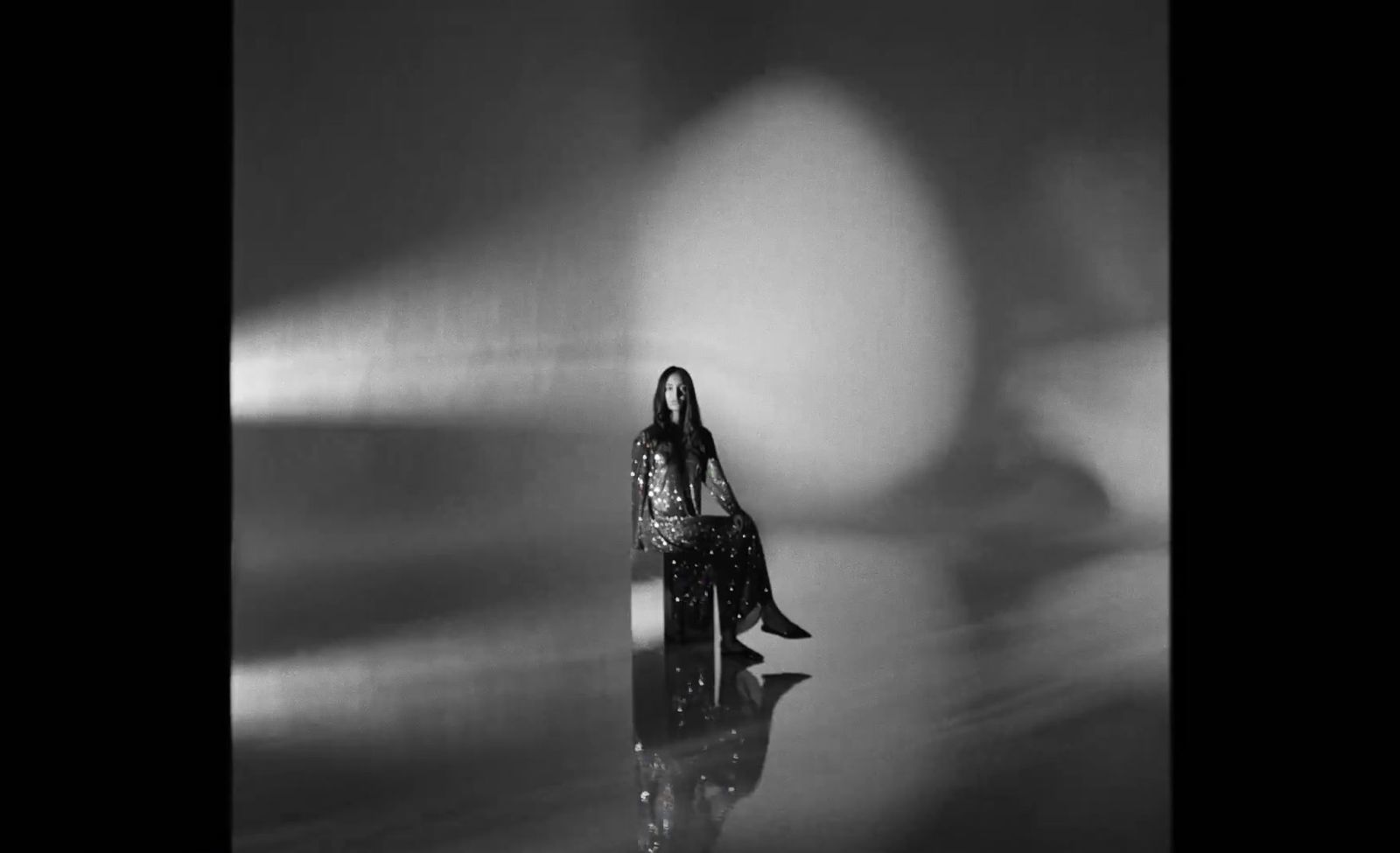 a black and white photo of a woman sitting on a chair