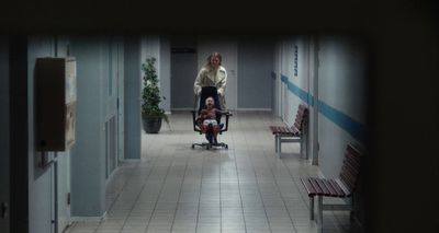 a woman is walking down a hallway with a child in a stroller
