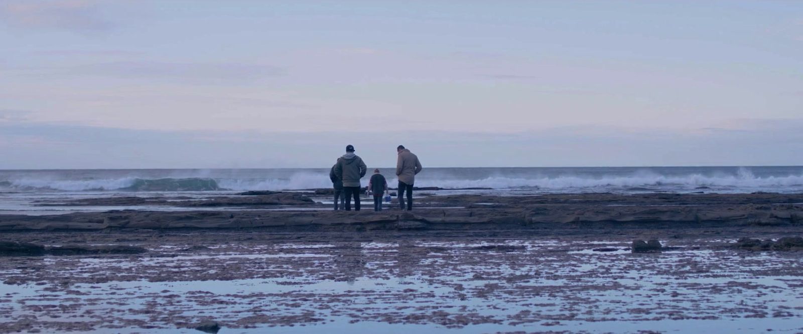 a couple of people standing on top of a beach