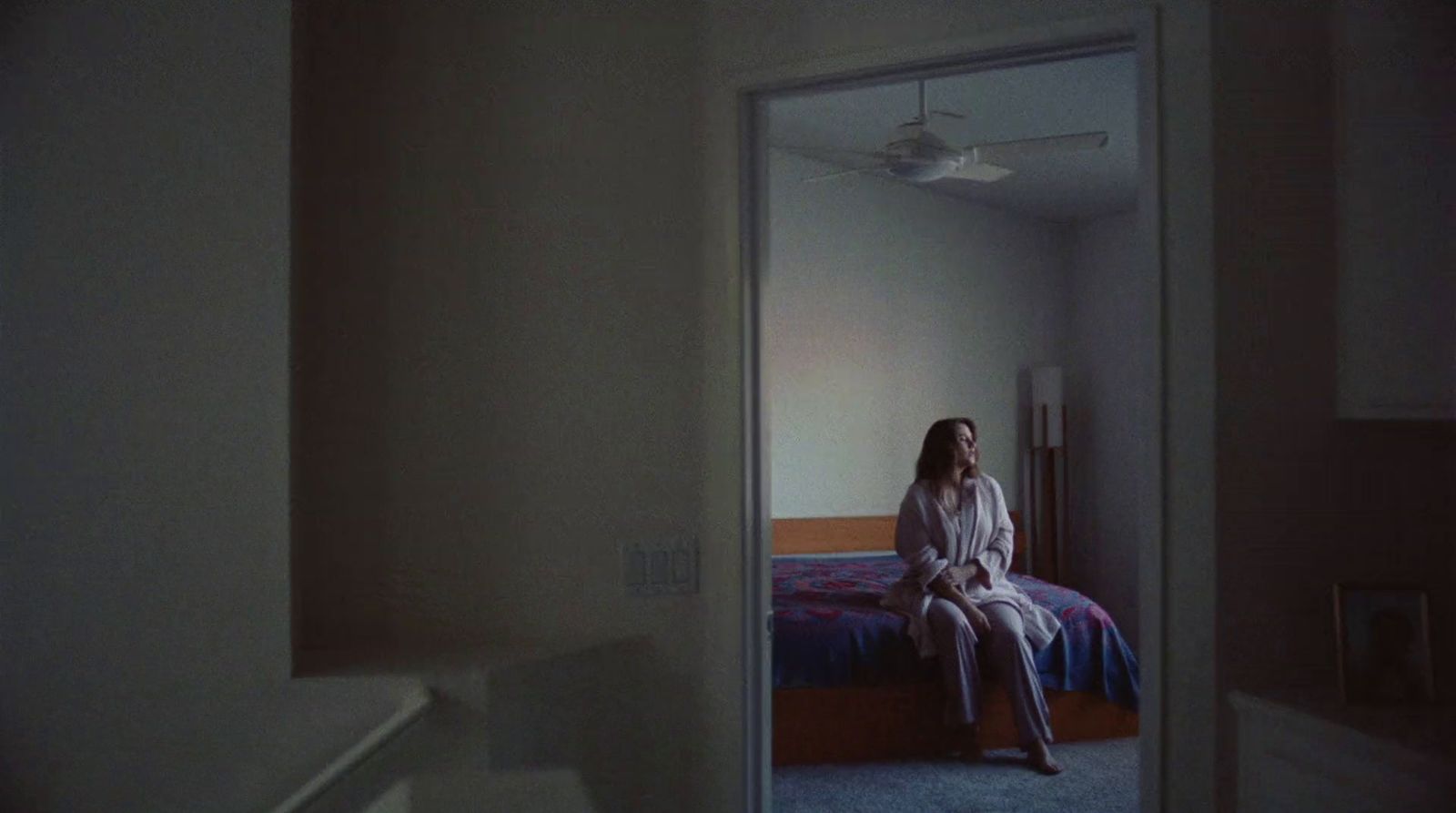 a woman sitting on a bed in a room