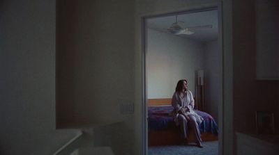 a woman sitting on a bed in a room