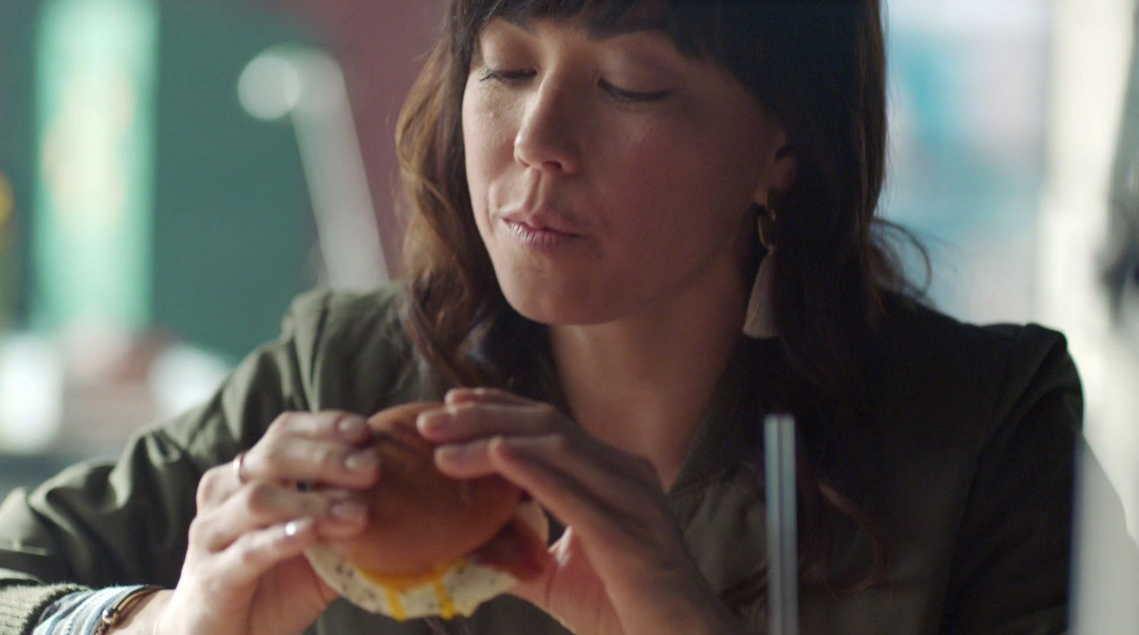 a woman sitting at a table eating a donut