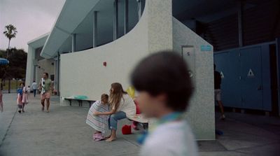 a group of children sitting on a bench in front of a building