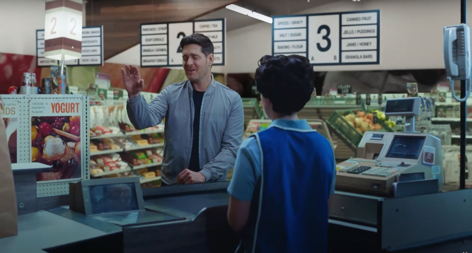 a man is talking to a customer in a grocery store