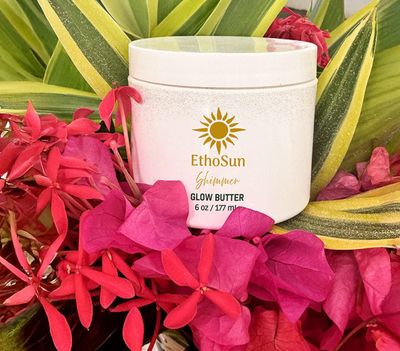 a jar of glow butter surrounded by flowers