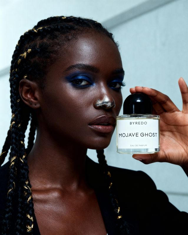 a woman holding a bottle of makeup in her hand