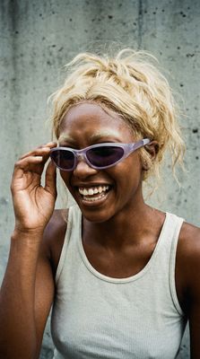 a woman wearing sunglasses and smiling for the camera