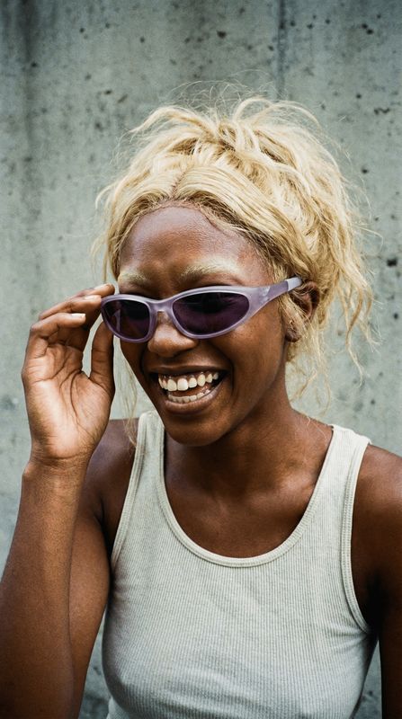 a woman wearing sunglasses and smiling for the camera