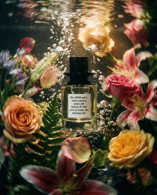 a bottle of perfume surrounded by flowers