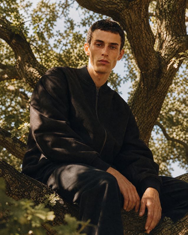 a man sitting in a tree with his legs crossed