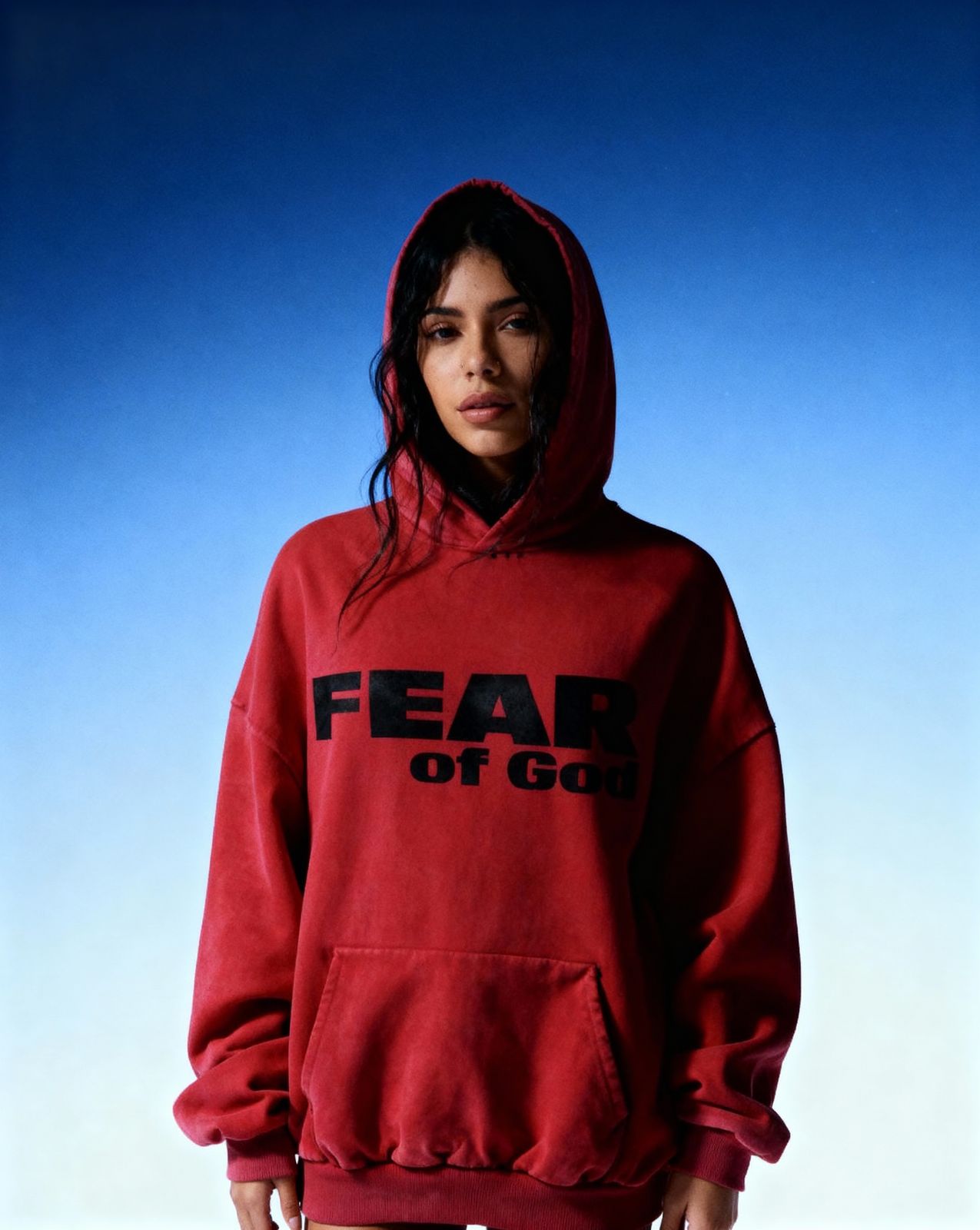 a woman wearing a red hoodie that says fear of god