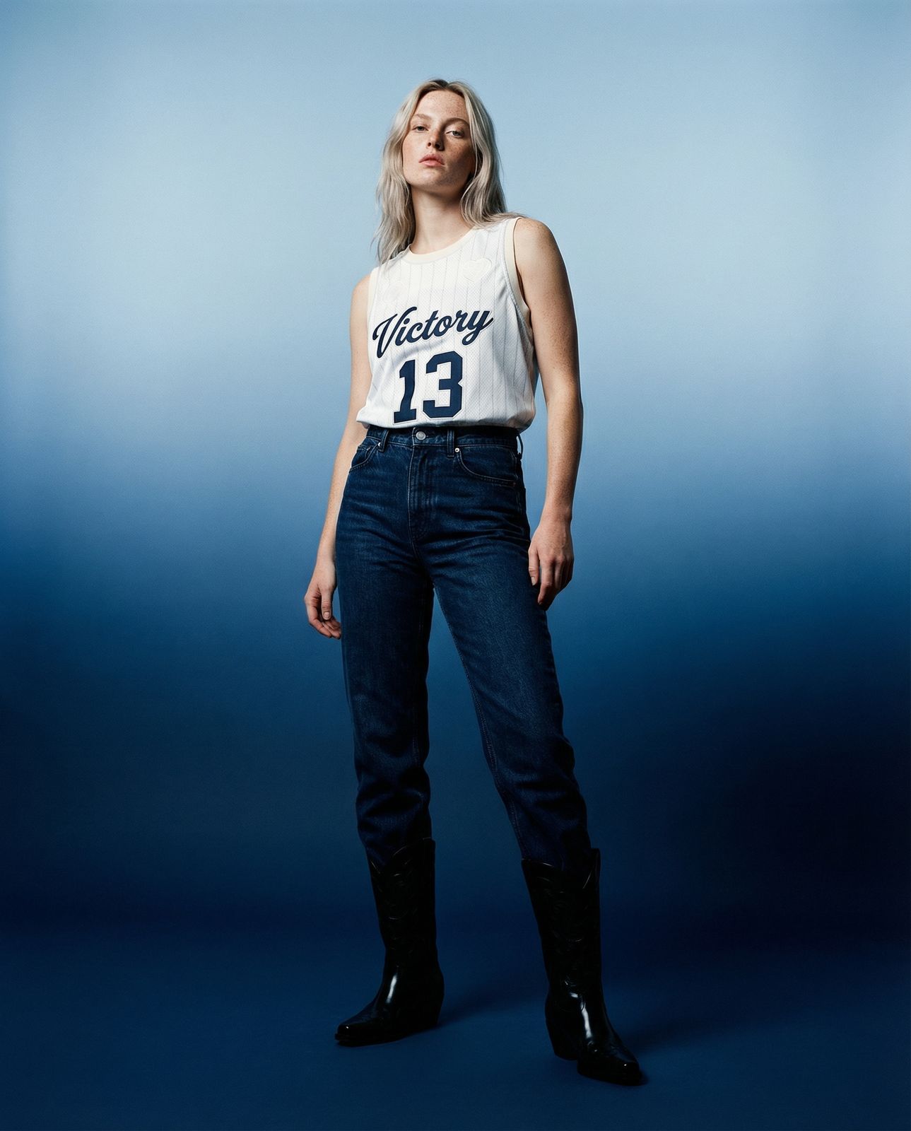 a woman in a white shirt and jeans posing for a picture