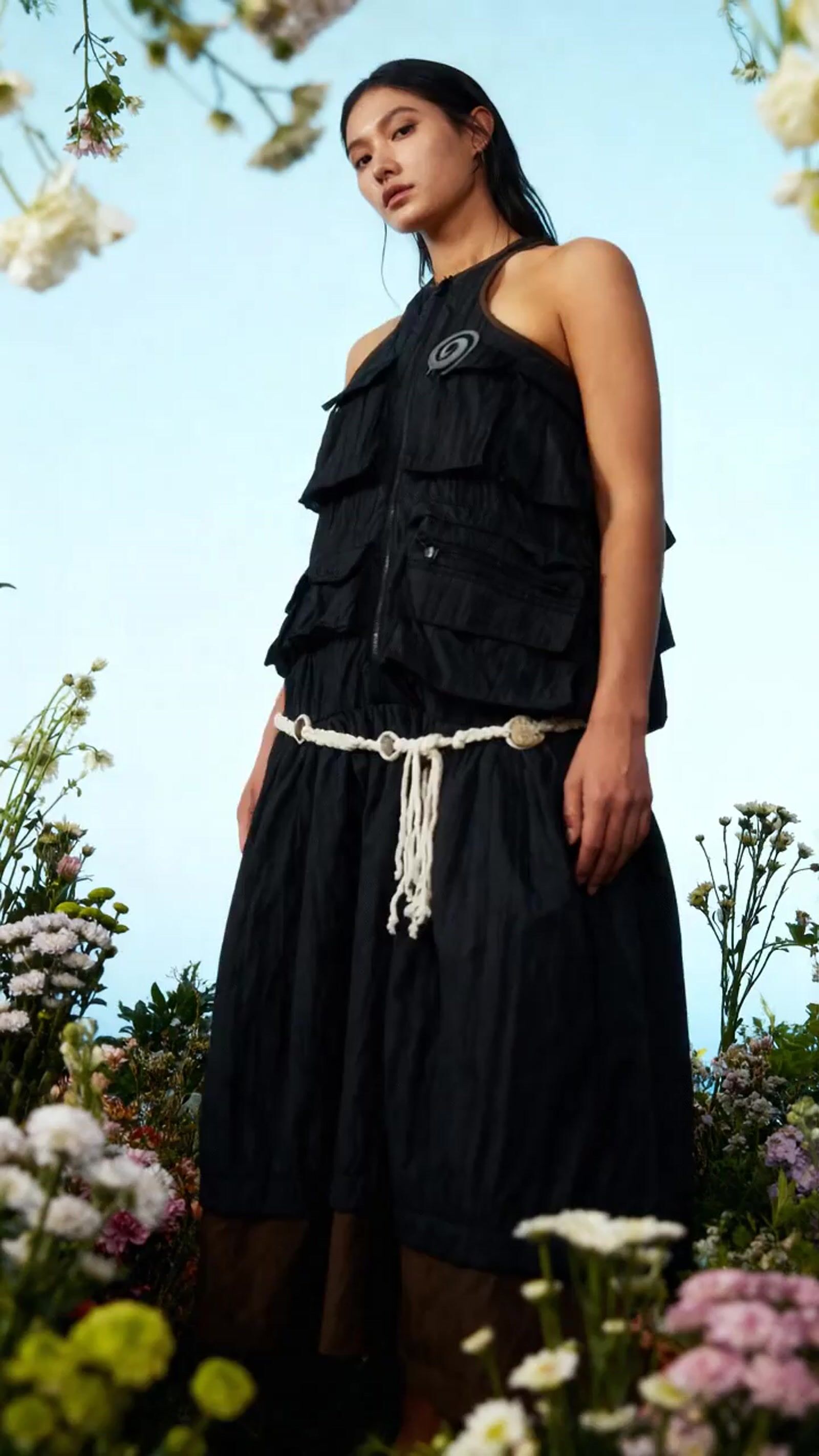 a woman standing in a field of flowers