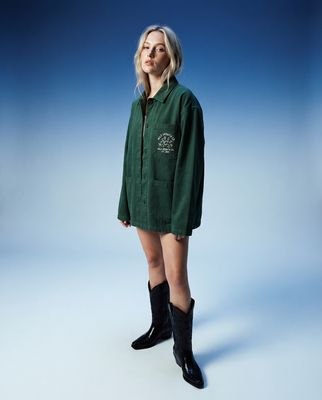 a woman in a green shirt and black boots