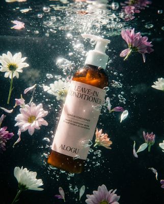 a bottle of leave - on conditioner surrounded by flowers