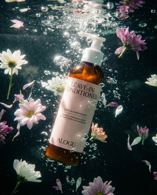 a bottle of leave - on conditioner surrounded by flowers