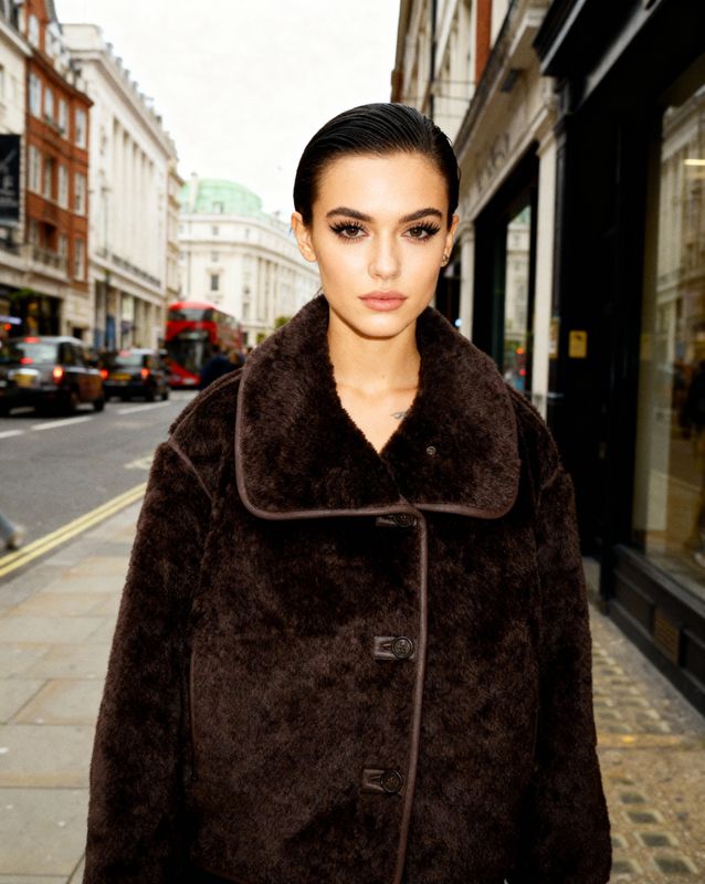 a woman standing on a sidewalk in front of a building