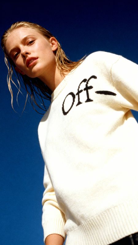 a woman wearing a white sweater with the word off on it