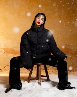 a woman sitting on a stool in the snow