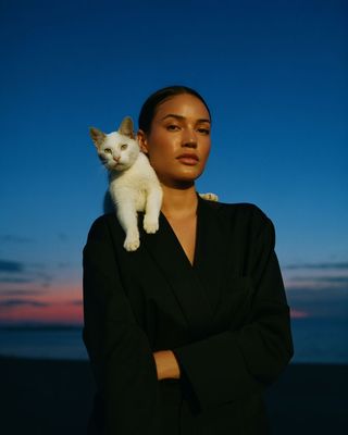 a woman holding a white cat in her arms