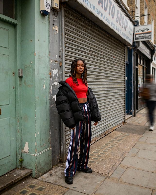 a woman standing on a sidewalk next to a garage door