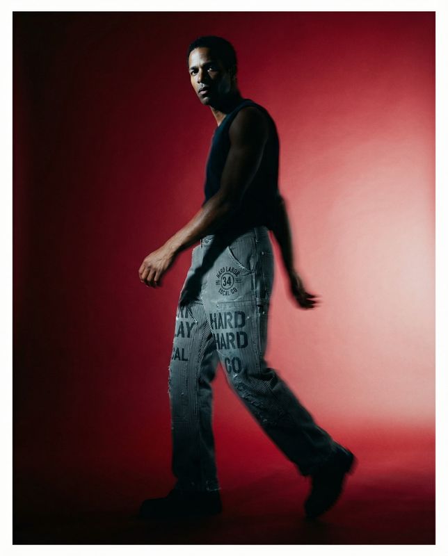 a man in black shirt and jeans walking