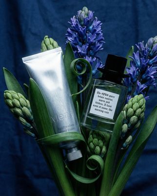 a vase filled with blue flowers and a tube of cream