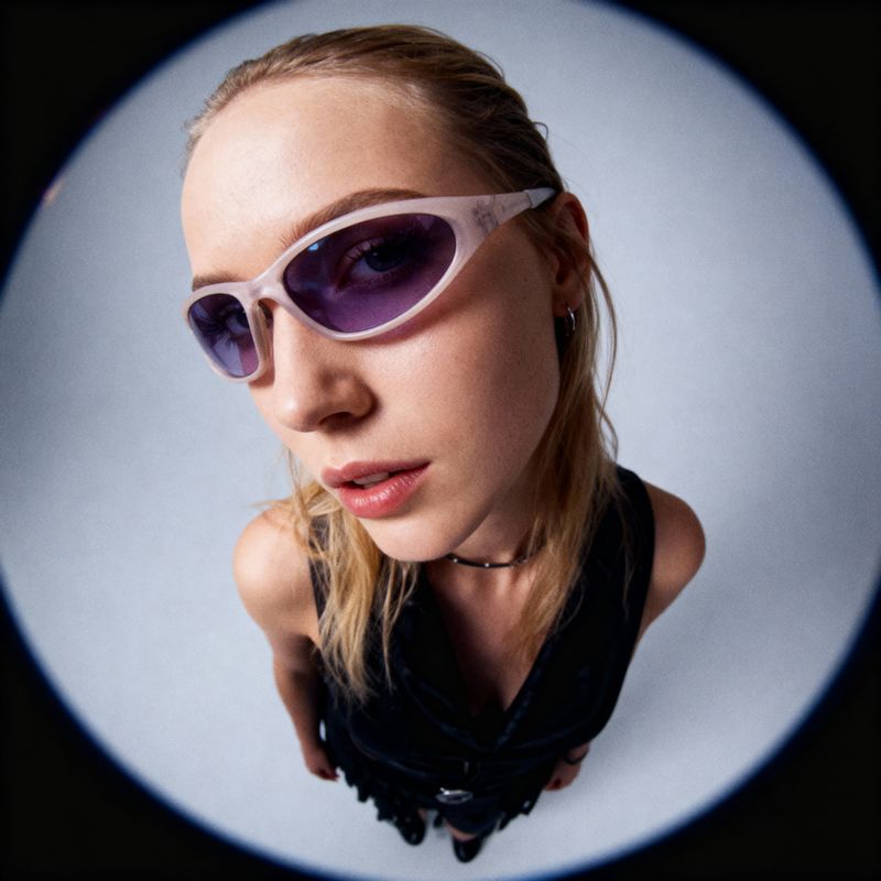 a woman in a black top and purple sunglasses