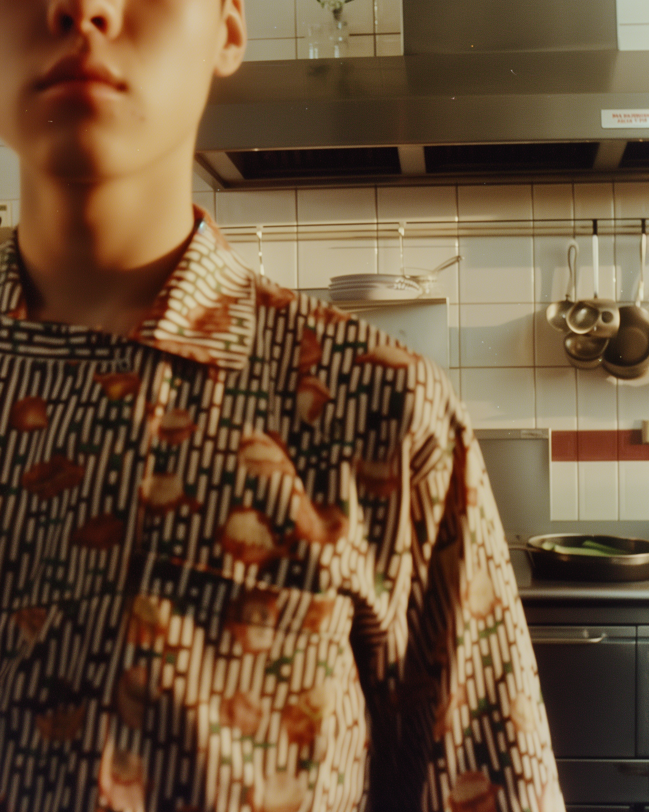 a man standing in a kitchen next to a stove top oven