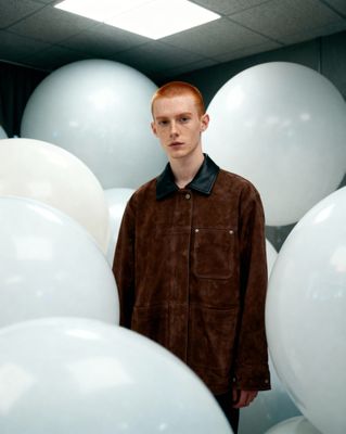 a man standing in a room filled with white balloons