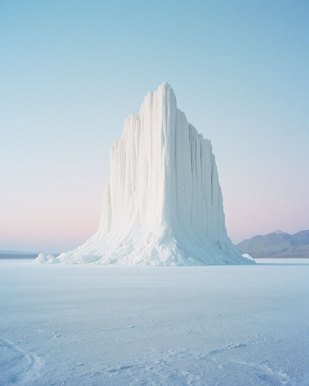 a very tall snow covered mountain in the middle of nowhere