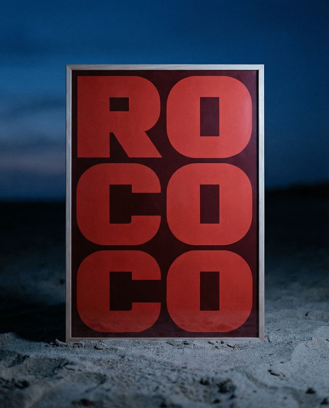 a red and black sign sitting in the sand