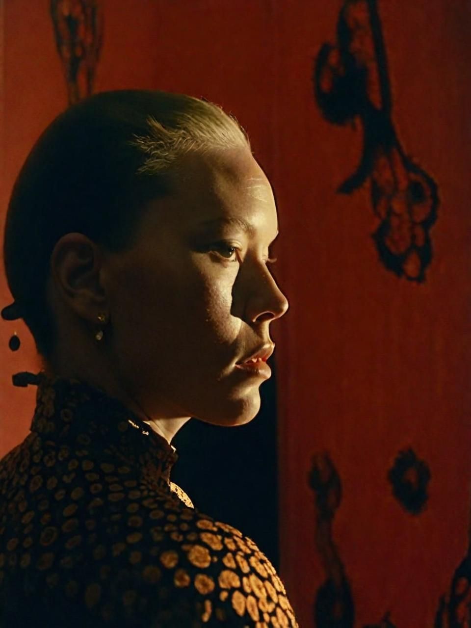 a woman standing in front of a red wall