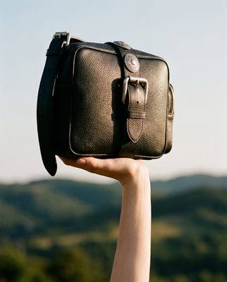 a person holding a piece of luggage in their hand