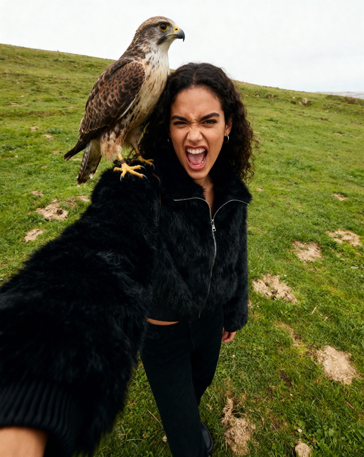 a woman is holding a bird on her arm