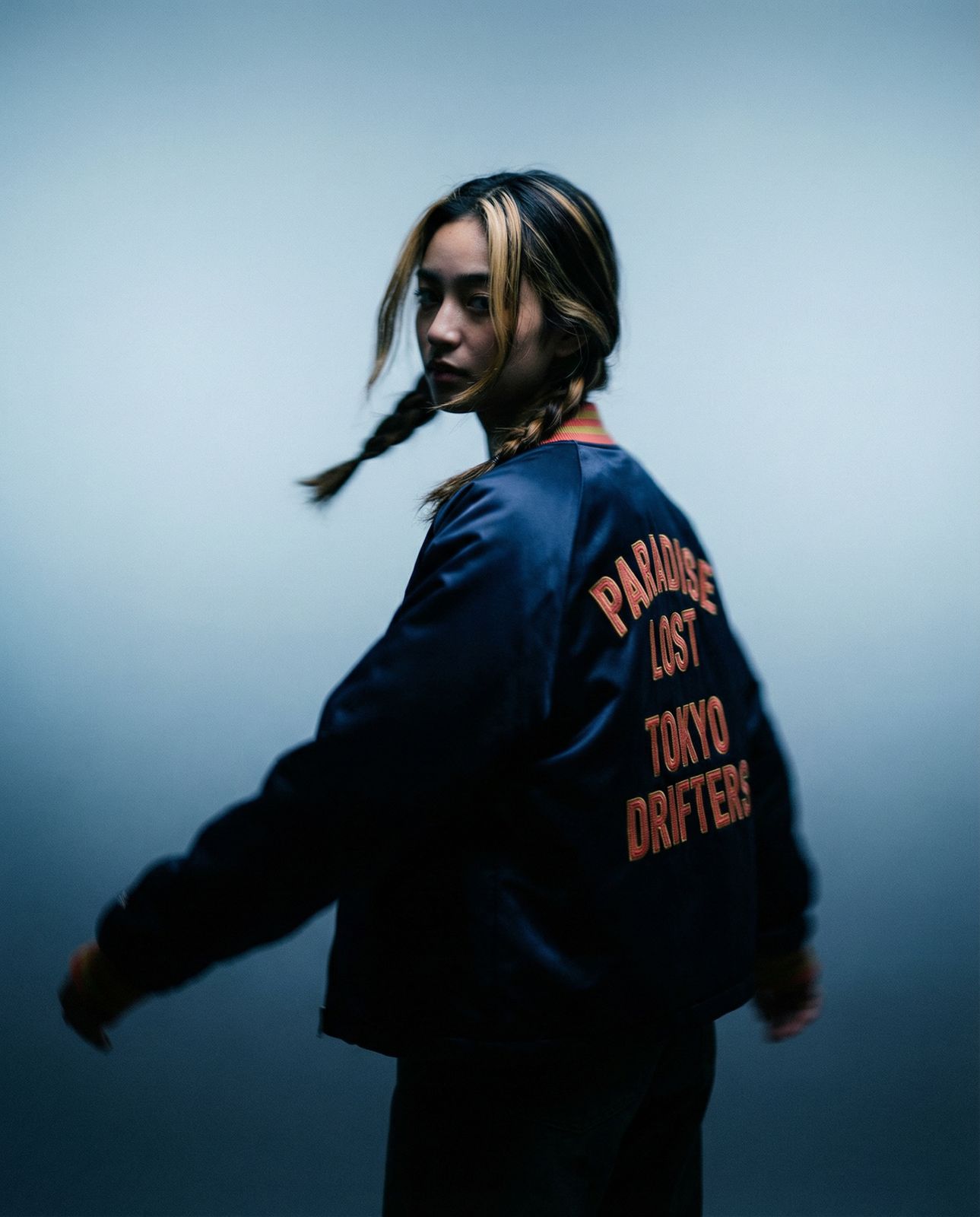 a man with long hair wearing a blue jacket