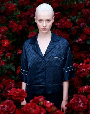 a woman standing in a field of red flowers