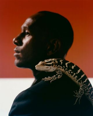 a man with a lizard on his shoulder