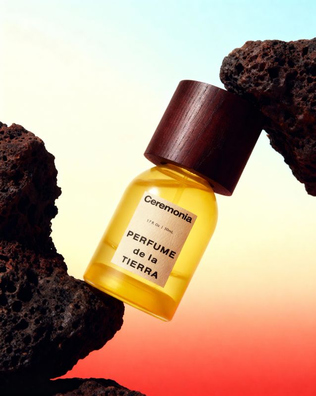 a bottle of perfume sitting on top of a rock