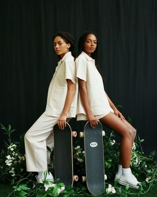 two young women sitting on top of skateboards