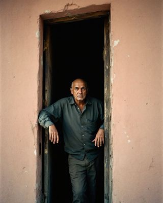 a man standing in a doorway with his hands on his hips